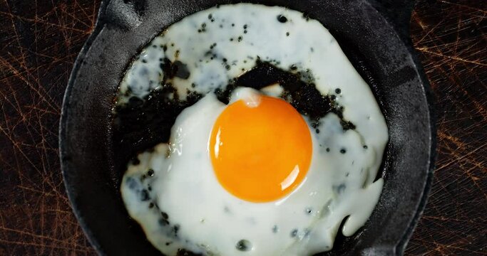 Frying pan with fried egg rotates slowly.