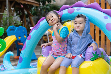 Fototapeta na wymiar Asian children playing in inflatable baby pool.
