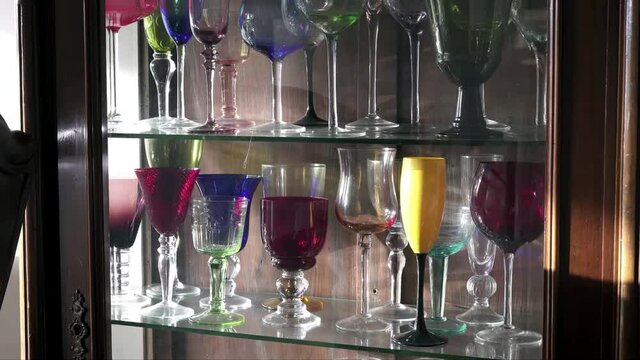 Zoom to wine glasses in the old wooden showcase shelf.