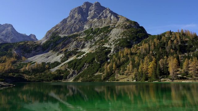 View of Sonnenspitze mountain in autumn with the tranquil lake Seebensee in the foreground. Alps, Austria