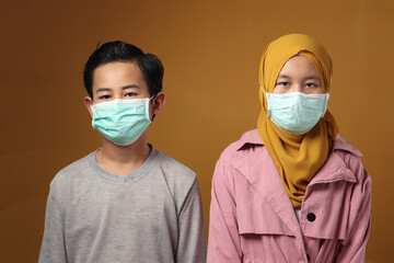 Boy and girl, brother and sister wearing medical mask to prevent covid coronavirus infection,...