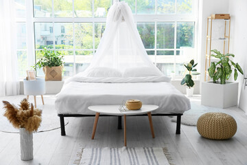 Big comfortable bed with clean linen in room © Pixel-Shot