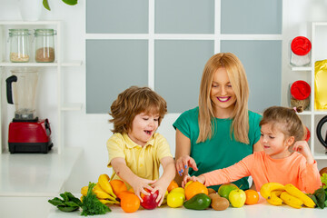 Superfood family concept. Healthy kids food. Mother daughter and little son preparing healthy smoothie in the modern kitchen.