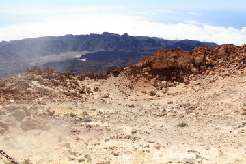 Mount Teide volcanic crater with fumarole emitting sulfur dioxide and mountain panorama on Canary Island Tenerife, Spain