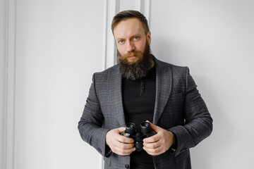 Bearded man in a jacket holds binoculars