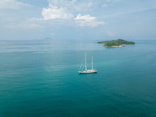 Fototapeta premium A large white sailboat that is calmly moored in the indigo of the Phuket sea.