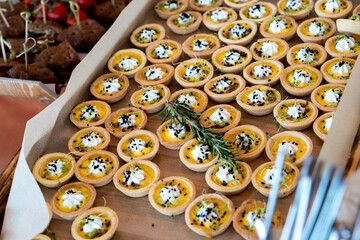 Top view of small bite sized pastries with cream and seeds