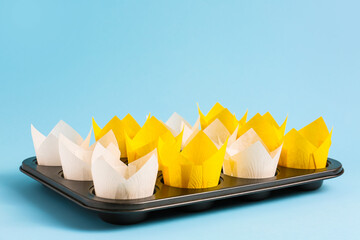 Muffin baking cups with tray on color background