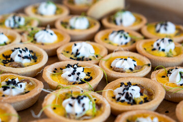 In focus small bite sized pastries with cream and seeds