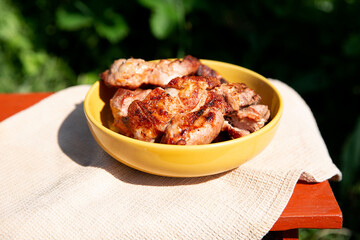 grilled meat lies on a yellow plate on a green natural background