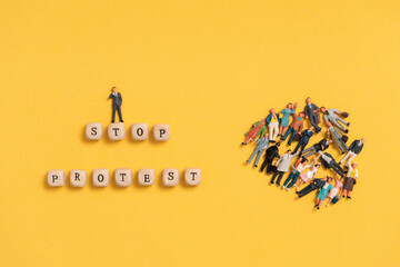 Miniature people. Protest affect business and social on yellow background. Stop protesting campaign concept.