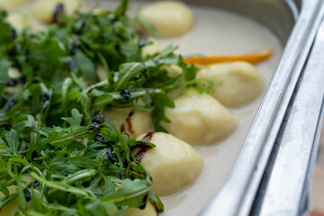 Closeup of vegetables covering tortellini with sauce.