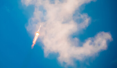 Take-off of a real launch vehicle from a spaceport. A rocket takes off into the sky against a background of clouds. Startup concept, power of science and technology.