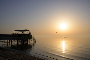 Silhouette fisherman wooden hut on seaview milky water over sunrise sky background, Bahrain.