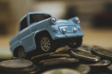 Obraz premium Model sky blue collar toy car park on stack coins.