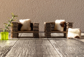 Reused corrugated cardboard furniture. Two couches on a hardwood floor. Room for copy.  - obrazy, fototapety, plakaty