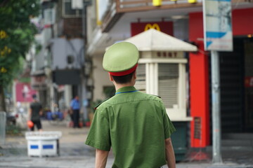 The young police stood in the middle of the intersection in Hanoi.
