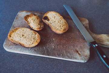 plant-based food, slices of sourdough bread toasted and placed on cuttin board with knife next to them