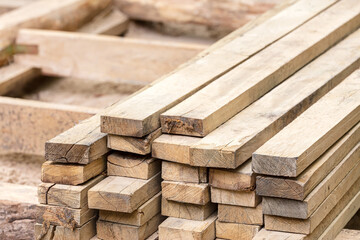 lumber stack of natural rough wooden boards on building site. material for construction.