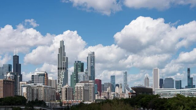 Time lapse establishing shot of large puffy clouds flowing through blue sky over the Chicago skyline as seen from the South Loop neighborhood