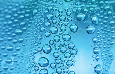 Close up water drops on sky blue tone background. Abstract sky blue wet texture with water drops on glass surface. 