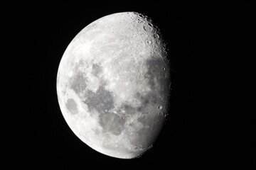 Moon in the night sky showing texture on the surface with visible craters. 