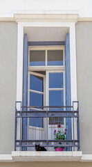 vintage house small balcony with black cat and potted flower in down town Athens, Greece