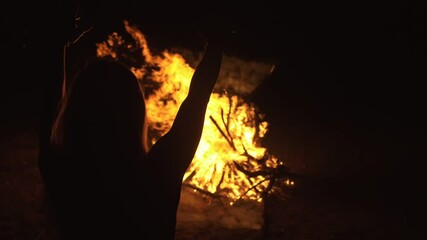 Silhouette of mystic woman in black background of fire fly flame, spark, of contour outline. Adult sexy of young girl witchcraft ceremony ritual dance in underclothes. Outdoor slow motion. Caucasian.
