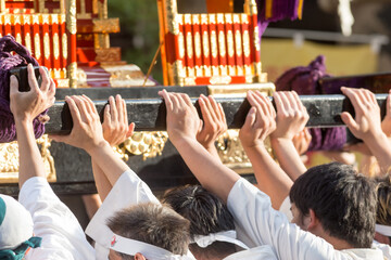 Chiba, Japan, 08/22/2019 , Hands of the participants of the 893rd Myoken Big Festival lifting the wooden structure that support the Mikoshi, a sacred religious palanquin (portable shinto Shrine) - obrazy, fototapety, plakaty