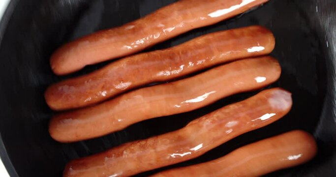 Sausages fried on a hot pan.
