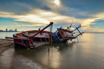 The remains of a blue fishing boat sunk on the beach are left amidst tranquility.