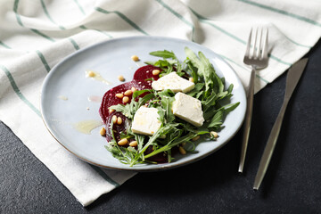 Plate with arugula, beet and feta salad. Sprinkled with pine nuts and honey