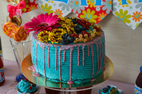 delicious sweet dessert turquoise colored birthday cake decorated with fresh flowers and berries currants and blueberries