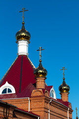 Fototapeta na wymiar Golden cross on the dome of an Orthodox church close-up.