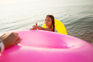 Close-up pf mother hand  holding the rubber ring and give to the childe swimming in the water/