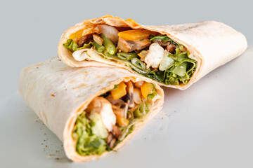 Shawarma sandwich - fresh roll of thin lavash or pita bread filled with grilled meat, mushrooms, cabbage, carrots