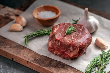 Prepared for grilling Raw steak filet Mignon beef on a wooden table with herbs
