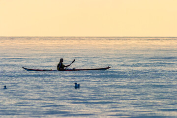 Kayak paddling at sea in sunset
