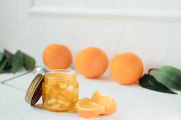 orange jam on a white background .glass jar of orange jam with fresh fruit
