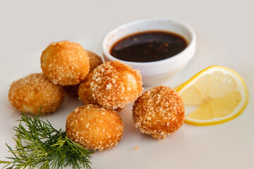 Fried breaded mozzarella cheese balls with tomato sauce