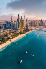 Aerial view of the city of Dubai; Dubai Marina view during vibrant sunset with skyscrapers and beaches
