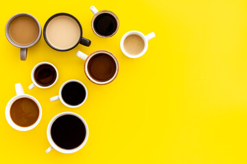 Lots of coffee on yellow table top view copy space