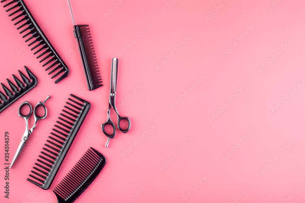 Sticker combs, hairbrush, scissors on pink desk from above copy space