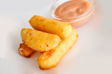 Breaded mozzarella cheese sticks with ketchup and bbq sauce