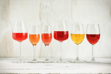 Collection of a various of wine in a glass, rose, red, white and champagne on a white wooden rustic table. Set of wines in a row on a vintage background.