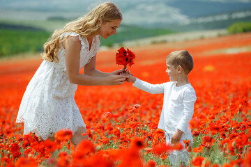 A small child gives flowers to a woman. 