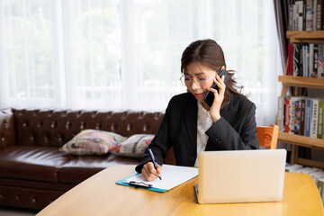 Beautiful young asian woman working with the laptop via the internet at home. Working Distance Freelance independent professional. Coronavirus prevention social distance policy,self quarantine concept