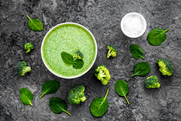 Broccoli and spinach cream soup on grey desk from above. Vegetable pattern