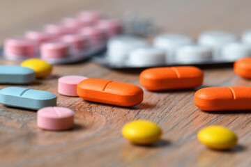 Assorted colored tablets and tablet packaging close-up on the table. Concept of protection and treatment of coronavirus infection.