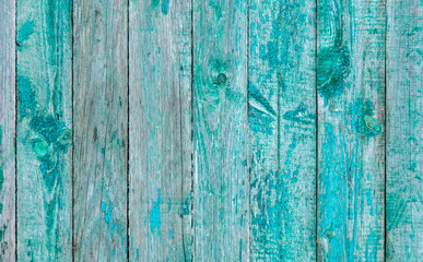 Fototapeta na wymiar Wooden boards on an old blue fence as an abstract background.